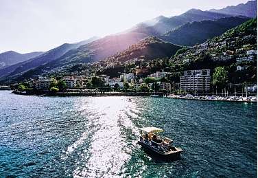 Croisière sur le lac Majeur près de Brissago dans la lumière du soir avec vue sur les montagnes, le lac et la rive.