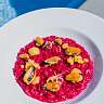 Risotto rouge aux fruits de mer – moules et saint-jacques sur un risotto vif, servi sur une assiette blanche