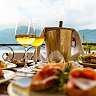 Apéritif avec vin blanc, sandwichs et antipasti sur la terrasse du Sunstar Hotel Brissago avec vue sur le lac Majeur et les montagnes environnantes.