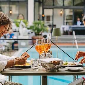 Coppia che gusta un pranzo sulla terrazza della piscina al Sunstar Hotel Brissago