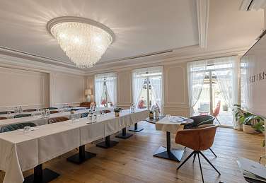 Lichtdurchfluteter Meetingraum im Sunstar Hotel Brissago mit Schulform-Bestuhlung, weissen Tischdecken, Kristallleuchter und grosszügigen Fenstern mit Blick auf den Aussenbereich